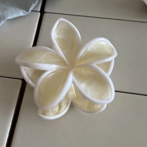 Dettaglio molletta per capelli a fiore in acetato con finitura marmorizzata lucida