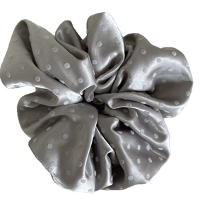 Elegant gray satin scrunchie with white polka dots for a gentle and stylish hair bun look