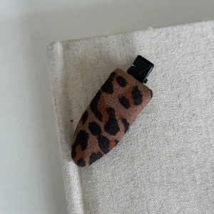 Detail view of leopard print fabric hair clip with a non-slip metal duckbill grip