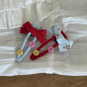 Détail de barrettes BB en tissu faites main avec pois, nœuds et boutons