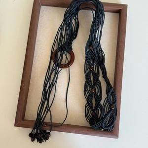Detail of handcrafted bohemian waist chain with black woven cord and wooden beads