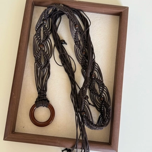 Detailed close-up of dark brown bohemian braided waist chain with round wooden beads