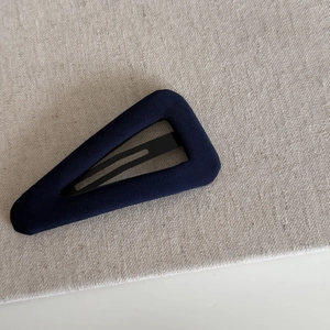 Detail shot of navy blue striped fabric-covered triangular BB hair clip for women