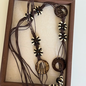 Detail of bohemian waist chain featuring dark brown wax rope and carved coconut shell rings