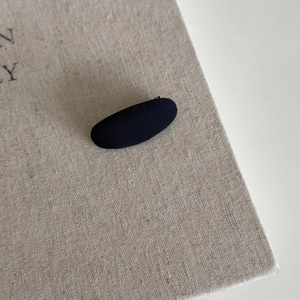 Detail showing the navy striped fabric texture on a minimalist oval hair clip