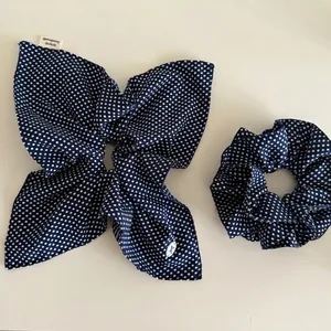 Ensemble chouchou et élastique à nœud bleu marine à pois, présentation à plat élégante