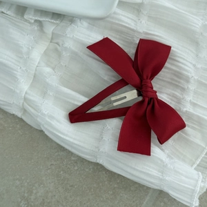 Detail view of the handmade dark red ribbon bow hair clip with a metal duckbill clip