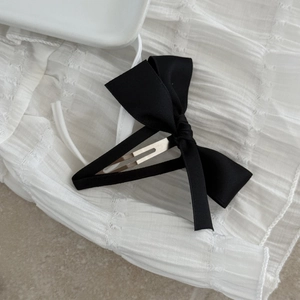 Macro view of a sweet black satin bow hair clip with silver metal BB clip attachment