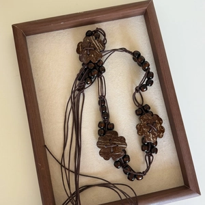 Detailed view of bohemian wood bead waist chain with coconut shell flowers and long tassels