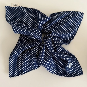 Détail de l'élastique à cheveux bleu marine à pois avec une étiquette faite main