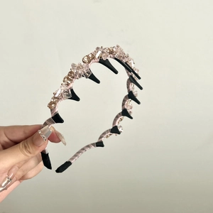 Détail du serre-tête rose perlé de cristaux avec peigne à dents de requin noir