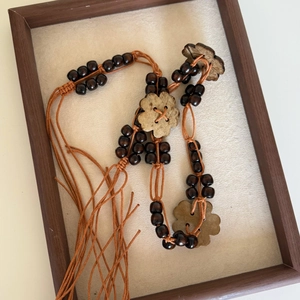 Detailed close-up of handmade bohemian waist chain with wooden beads and flower pendant