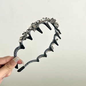 Détail d'un serre-tête ondulé en perles de cristal avec satin gris et dents de maintien