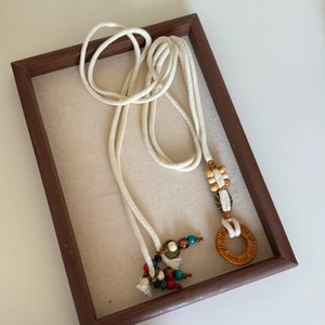 Detail view of Bohemian braided waist chain with colorful beads on a wooden tray