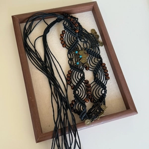 Detail of bohemian waist chain with black braided cord, turquoise beads and vintage coins