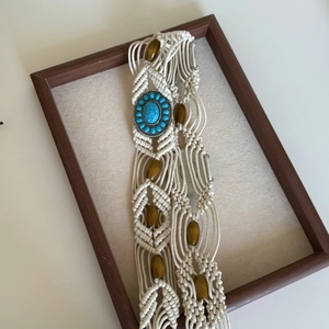 Detail of woven Bohemian waist chain with turquoise insert and dark brown wooden beads