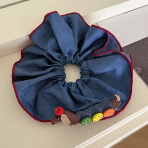 Detail of blue denim hair scrunchie with cute felt dachshund doll and colorful buttons