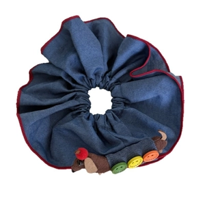 Blue denim scrunchie with red piping and a cute plush dog wearing colorful buttons