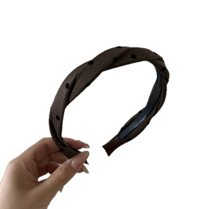 Minimalist brown twisted polka dot headband with anti-slip teeth on white background