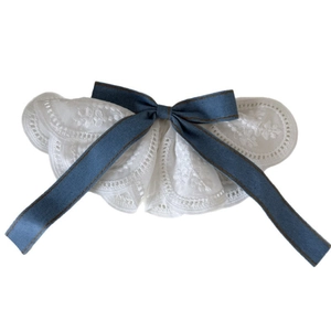 Col en dentelle blanche élégant avec ruban en jean bleu sur un fond blanc propre