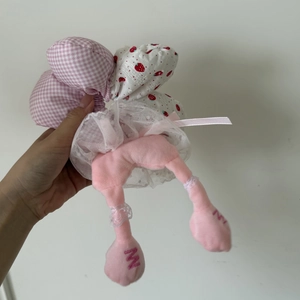 Close-up of pink checkered plush scrunchie with lace skirt and strawberry pattern