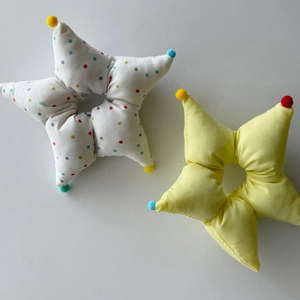 Macro view of plush star hair scrunchies with colorful polka dots and pom-poms