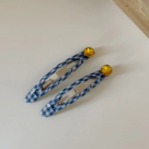 Detail of blue plaid fabric hair clips with yellow faceted rhinestone embellishments
