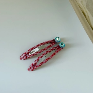 Close-up of red and white plaid BB hair clips with light blue square crystal accents