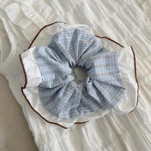 Dettaglio di elastico per capelli coreano con quadretti blu-grigi e bordo plissettato bianco