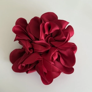 Detailed close-up of dark red satin floral hair scrunchie with layered fabric petals