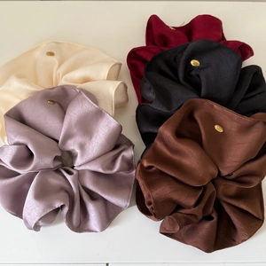 Five-piece set of textured satin scrunchies with elegant gold metal logo charms