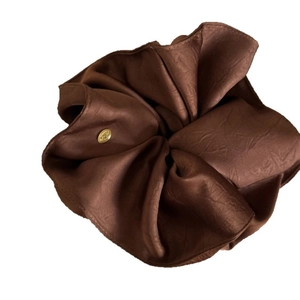Chocolate brown satin scrunchie with French texture and gold metal logo tag