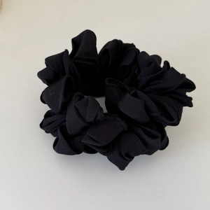Elastico per capelli a pieghe nero stile francese con trama ondulata opaca su sfondo bianco