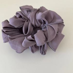 Dettaglio macro dell'elastico per capelli a petalo increspato in viola fumé