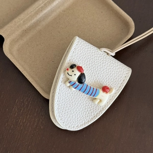 Macro shot of white lychee leather texture with a 3D cute cartoon dachshund dog pendant