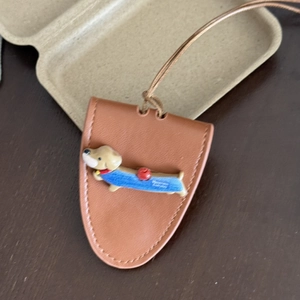 Close-up of brown leather dachshund eyeglass holder necklace with Happiness Everyday text