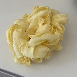 Vista dettagliata dell'elastico in chiffon giallo chiaro con bordi in tessuto pieghettato