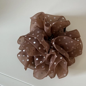 Detailed close-up of brown polka dot organza fabric on this elegant large hair clip