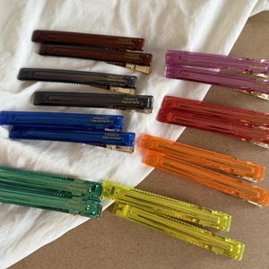 Flat lay of colorful semi-transparent acrylic duckbill hair clips with gold France lettering