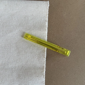 Detail view of a yellow translucent acrylic hair clip with Handmade engraving