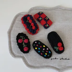 Vue détaillée des barrettes en crochet fait main avec broderie cerise et fleurs