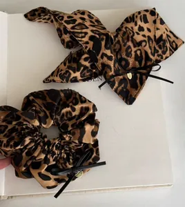 Détail d'un chouchou léopard et d'un nœud pour cheveux sur un livre au style élégant