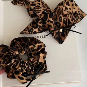Chouchou en Satin Imprimé Léopard Avec Grand Nœud Pendentif Cœur Doré Élastique Cheveux Tendance Accessoire Élégant Pour Femmes