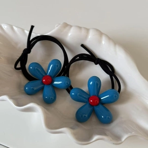 Blue flower hair ties with high elasticity bands in a white shell ceramic dish