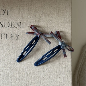 Close-up of vintage red and blue plaid bow hair clips on high-quality metal BB clips