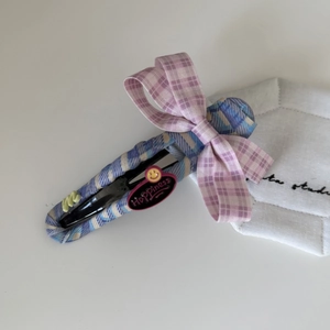 Cute blue plaid bow hair clip with Happiness charm on a clean minimalist white background