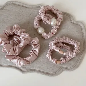 Pink satin hair scrunchies set with pearl details and ribbon ties for women