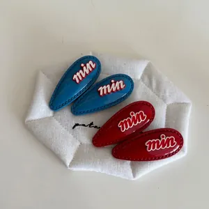 Set of retro red and blue heart drop-shaped hair clips with embossed min lettering