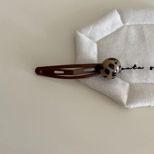 Detail of vintage brown metal BB hair clip featuring a leopard print resin accent