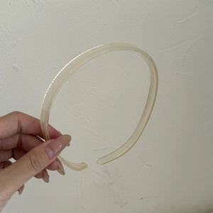 Détail des dents antidérapantes sur le serre-tête en plastique translucide crème